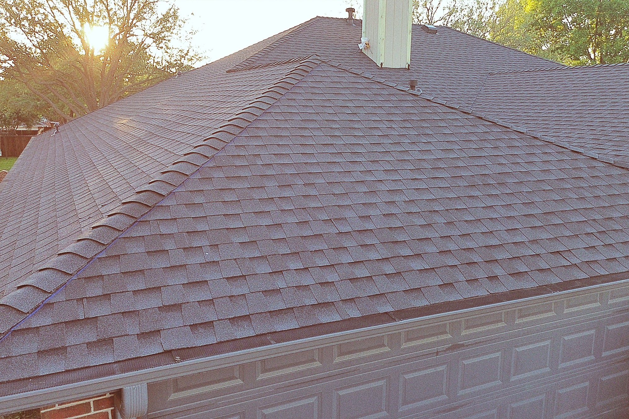 Close view of architectural shingles meeting at a hip on a new roof